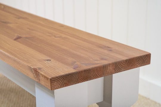 A wooden table with metal legs and a white base.